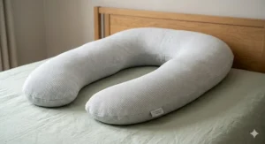 Parent using a U shaped maternity pillow as a comfortable support aid while breastfeeding.