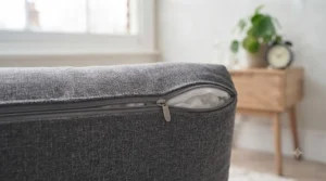 Unzipping the washable outer cover of a cost-effective husband pillow for easy machine laundering.