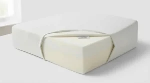 Side-profile illustration of a person sleeping comfortably on an elevated bed wedge pillow to alleviate acid reflux and heartburn.