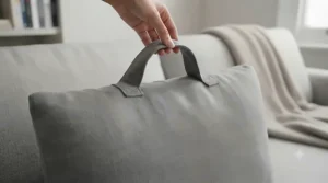 Close-up of a durable fabric carry handle on top of a reading pillow, making it easy to move between the lounge and bedroom.
