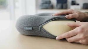 Removing the breathable, machine-washable cotton cover from a travel pillow.