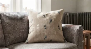 High-quality feather-filled square cushion providing soft support on a living room settee.