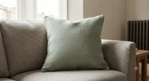 Neutral-toned square cushion styling a contemporary fabric sofa in a British home.
