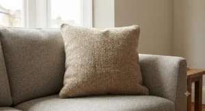 Close-up of a plump square cushion featuring a textured fabric design for living room comfort.