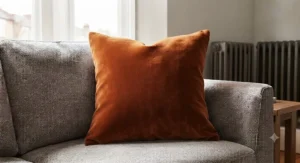 Luxurious velvet square cushion adding texture and warmth to a family lounge sofa.
